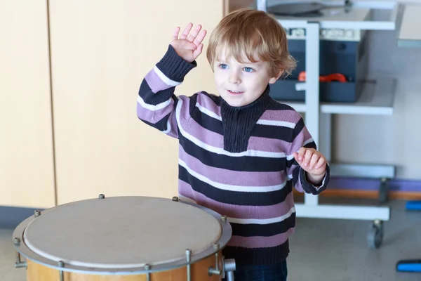 Little toddler boy playing drum at music school. — Stock Photo, Image