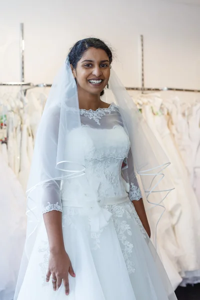 Young indian woman in wedding dress with bridal gowns on display — Stock Photo, Image