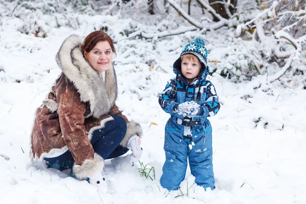 Mother and toddler boy having fun with snow on winter day — Stock Photo, Image