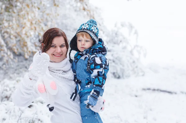 Moeder en peuter jongen plezier met sneeuw op winterdag — Stockfoto