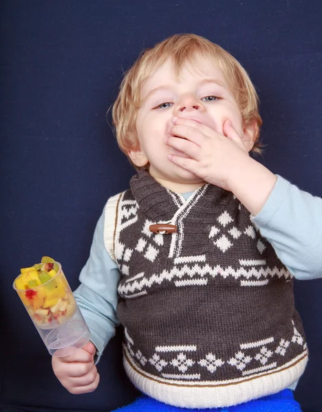 Kleine peuter jongen eten fruitsalade in push-up taart vorm. — Stockfoto