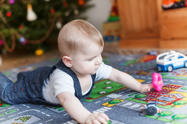 Kleine babyjongen en kerstboom — Stockfoto