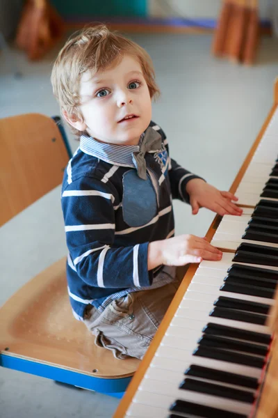 小さな幼児男の子の音楽学校でピアノを弾く. — ストック写真