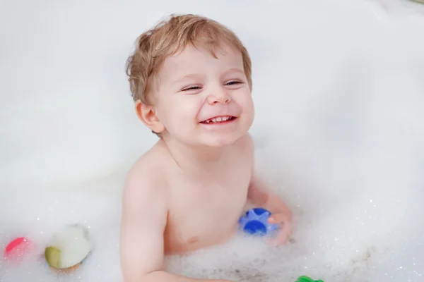 Adorabile ragazzo bambino biondo che si diverte con acqua facendo il bagno — Foto Stock