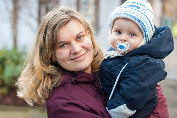 Giovane madre felice e il suo bambino bambino in fredda giornata autunnale — Foto Stock