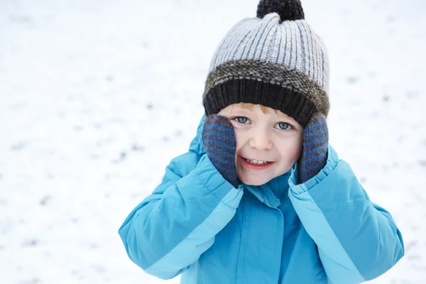 Очаровательный малыш веселится со снегом в зимний день — стоковое фото