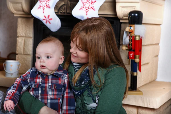 Schöne junge Mutter und entzückender Junge mit Weihnachtsdeko — Stockfoto