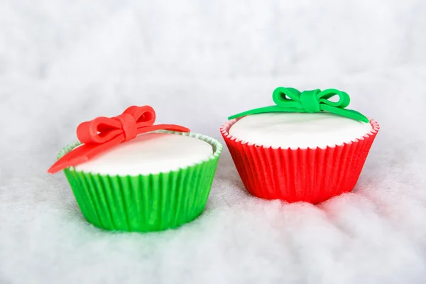 Different Christmas cupcakes on white snow background — Stock Photo, Image