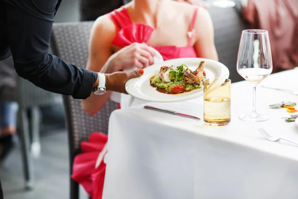 Serveur portant une assiette avec un plat de salade sur un mariage . — Photo