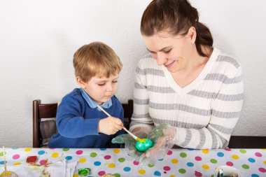 Anne ve oğlu, masada kapalı dekorasyon Paskalya yortusu yumurta.