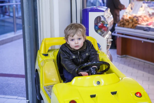 Petit garçon tout-petit sur la voiture sur l'aire de jeux — Photo