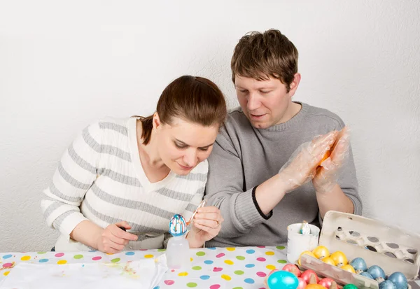 Couple Decorating Easter Eggs On Table indoor. — Stock Photo, Image