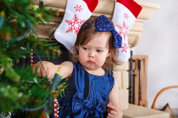 Niña feliz por el árbol de navidad y las luces — Foto de Stock