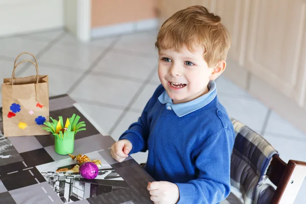 Menino pequeno sendo feliz sobre o ovo de Páscoa autofeito em espécie — Fotografia de Stock