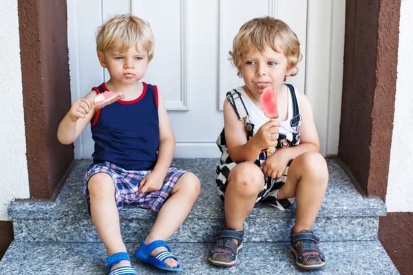 Two little twins boys eating ice cream — Stock Photo, Image