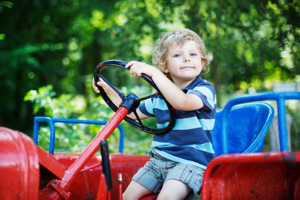 Portrét malý Plavovlasý chlapec v traktoru v létě — Stock fotografie