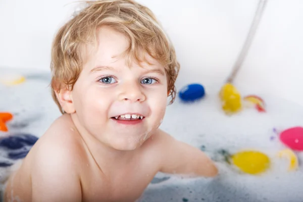 Schattige kleine peuter jongen van twee jaar met plezier door het nemen van bad ik — Stockfoto