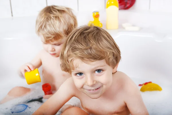 Dos niños gemelos divirtiéndose con agua tomando un baño en ba —  Fotos de Stock