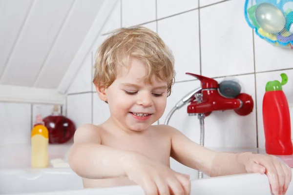 Schattige kleine peuter jongen van twee jaar met plezier door het nemen van bad ik — Stockfoto