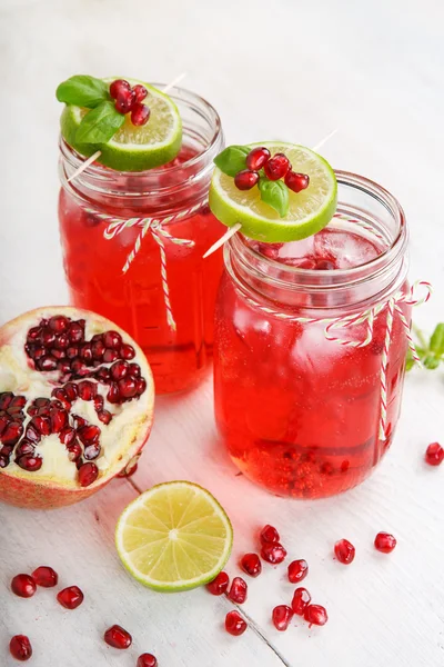 Dos vasos con zumo de pomgranato rojo, lima y menta . —  Fotos de Stock