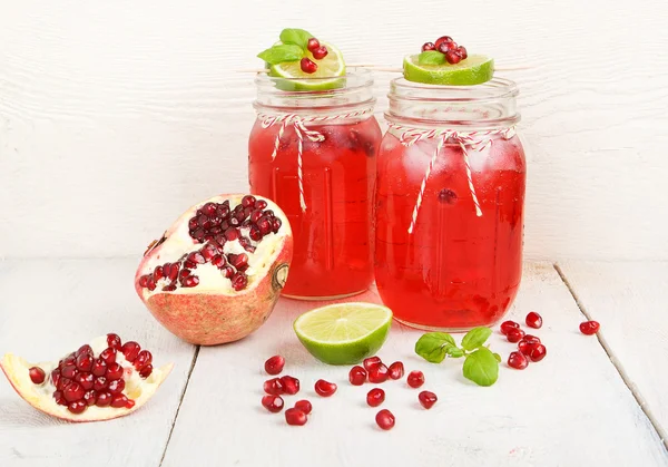 Due bicchieri con succo di pomgranato rosso, lime e menta . — Foto Stock