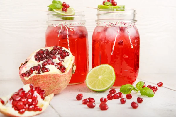 Dois copos com suco de romã vermelha, limão e hortelã . — Fotografia de Stock