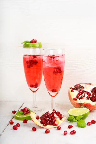 Två glas med röda pomgranate champagne, lime och mynta. — Stockfoto