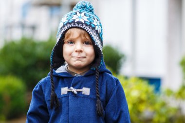 soğuk kış gününde gülümseyen şirin yürümeye başlayan çocuk portresi.