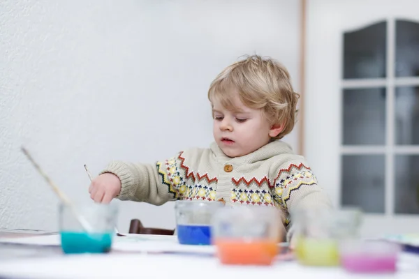 Cute toddler boy having fun indoor, painting with different pain — Stock Photo, Image