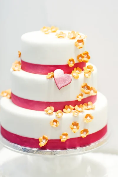 Wedding cake versierd met rozen-roze bloemen en harten . — Stockfoto