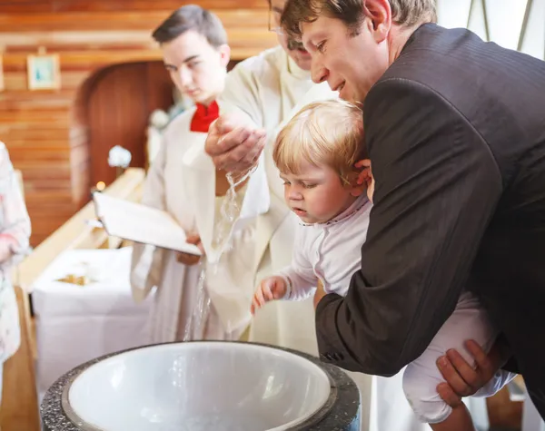 Little baby boy being baptized in catholic church holding by fat — Stock Photo, Image