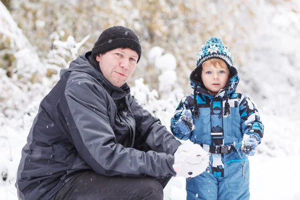 Vater und Kleinkind amüsieren sich am Wintertag mit Schnee — Stockfoto