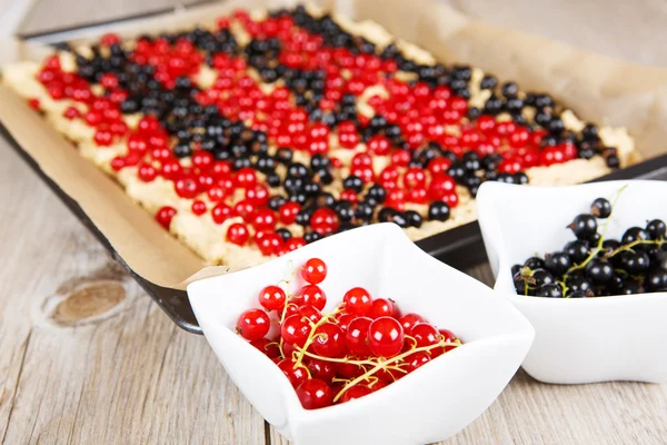 Red and black currant berries with home baked cake on background — Stock Photo, Image