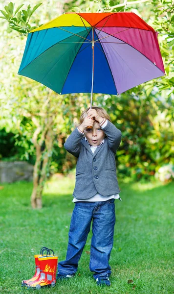 Pequeño niño lindo con paraguas colorido y botas, outdoo —  Fotos de Stock