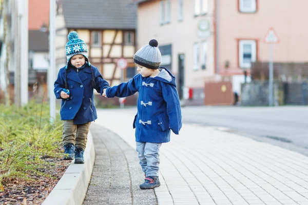 Twee kleine broer of zus jongens lopen op de straat in Duitse dorp. — Stockfoto