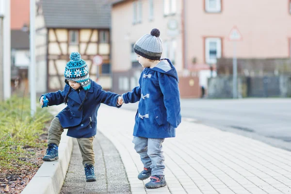 Two little sibling boys walking on the street in German village. — Stock Photo, Image