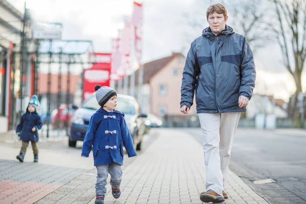 Baba ve iki küçük kardeş çocukları mikrop sokakta yürürken — Stok fotoğraf