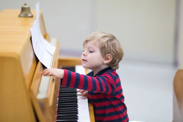 Двухлетний мальчик играет на пианино — стоковое фото