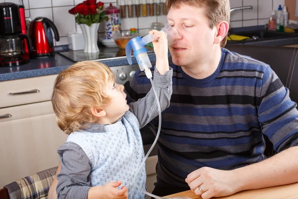 Niño y su padre haciendo inhalación con nebulizador — Foto de Stock