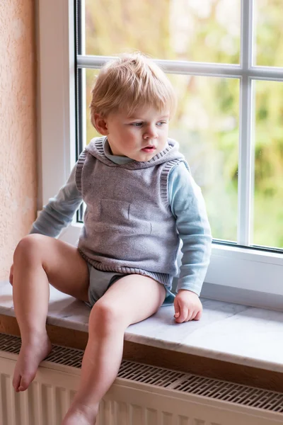 Adorable toddler boy looking out of the window — Stock Photo, Image