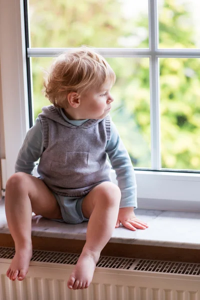 Adorable toddler boy looking out of the window — Stock Photo, Image