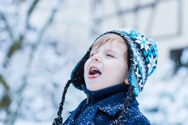 Menino pequeno se divertindo com neve ao ar livre na bela wi — Fotografia de Stock