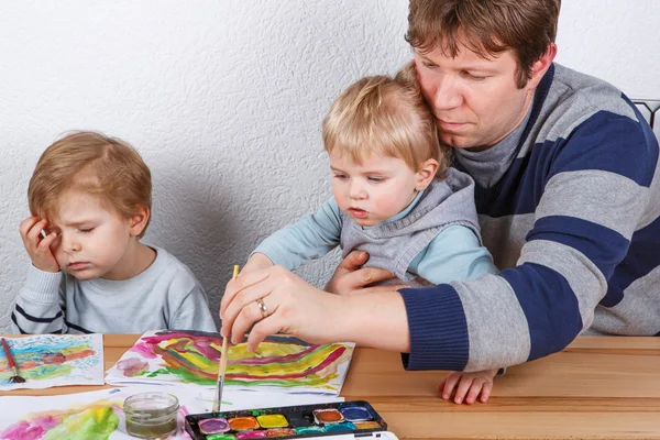 Pai e dois meninos irmãos se divertindo pintura — Fotografia de Stock