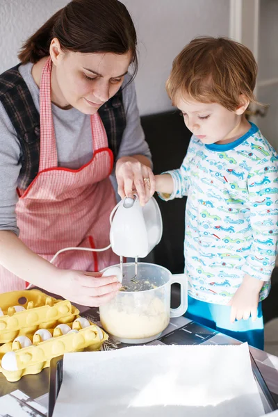 Little toddler boy and his mother having fun with baking at home — Stock Photo, Image