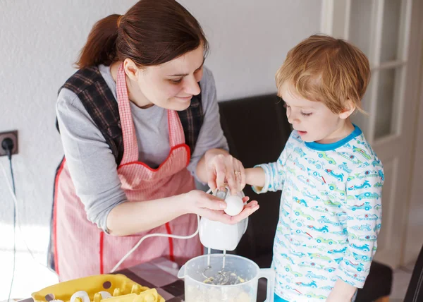 Lilla barn pojke och hans mor ha kul med bakning hemma — Stockfoto