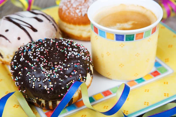 Chocolade en kokos donuts met carnaval decoratie. — Stockfoto