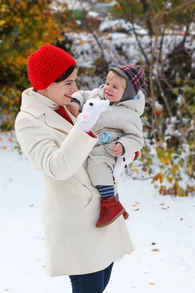 母亲和蹒跚学步的孩子冬天天过与雪的乐趣 — 图库照片