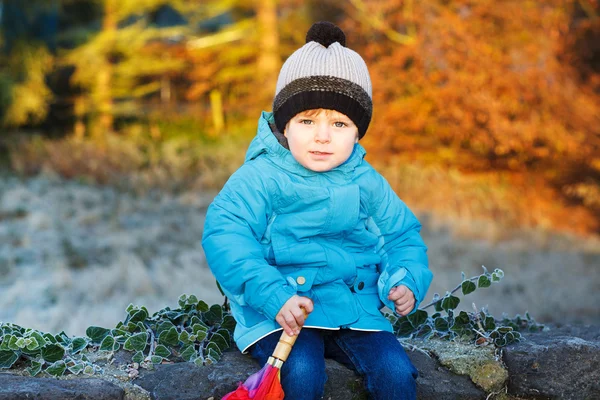 Portrait of adorable toddler boy with blue jacket and colorful u — Stock Photo, Image