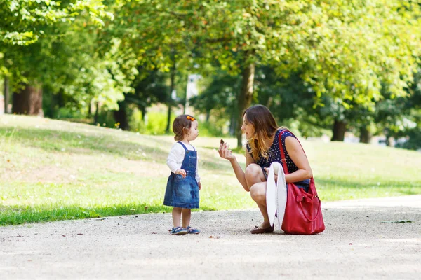 Ung kvinna och liten flicka på ett år går genom sommaren p — Stockfoto