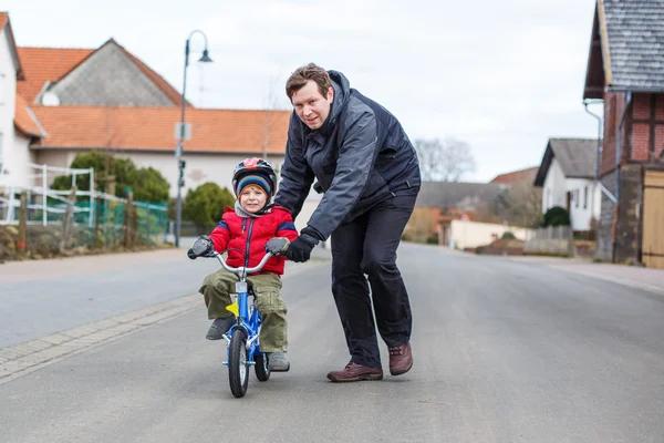 Молодой отец учит своего 3-летнего сына кататься на велосипеде — стоковое фото